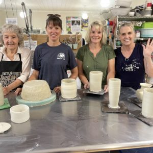 Carol, Lisa, Tina and Nancy standing behind fresh thrown pots